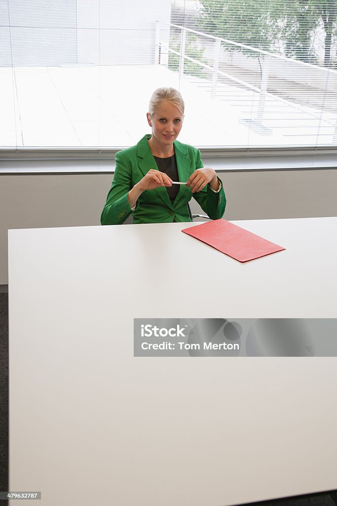 Businesswoman sitting at conference table  Businesswoman Stock Photo