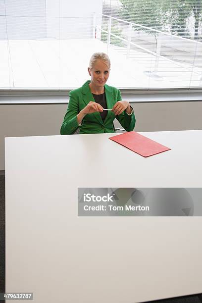 Businesswoman Sitting At Conference Table Stock Photo - Download Image Now - Businesswoman, Looking At Camera, Serious