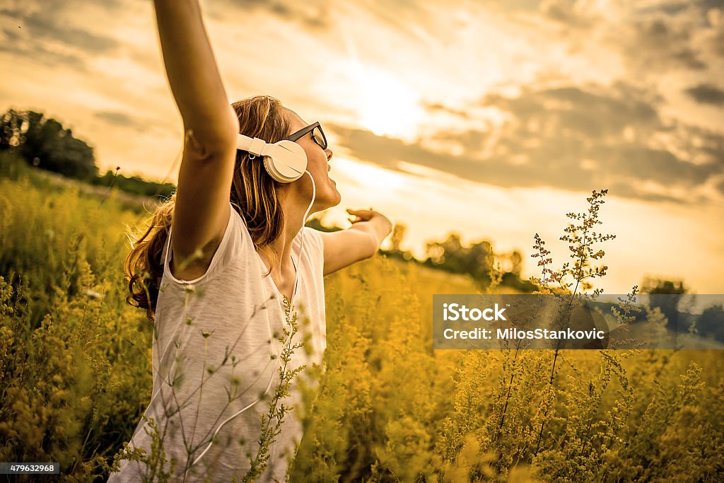 Freedom Happy girl listening music on headphones and enjoying in nature. Hipster Culture Stock Photo