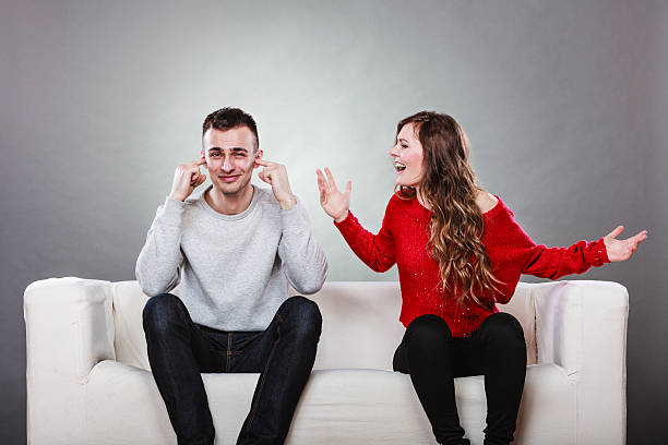 Angry fury woman screaming man closes his ears. couple having argument - conflict, bad relationships. Angry fury woman screaming man closing his ears. man closing ears photos stock pictures, royalty-free photos & images