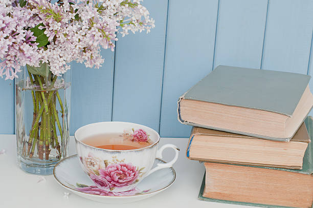 Bunch of lilac, books and teacup stock photo