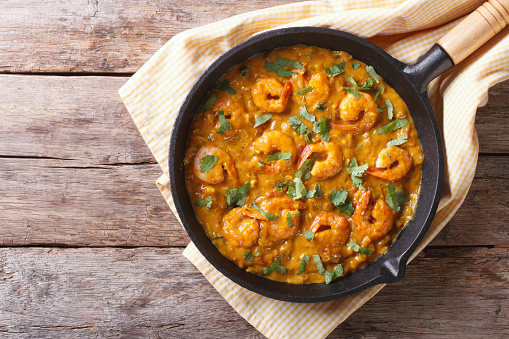 Shrimp in curry sauce in the pan. horizontal view from above