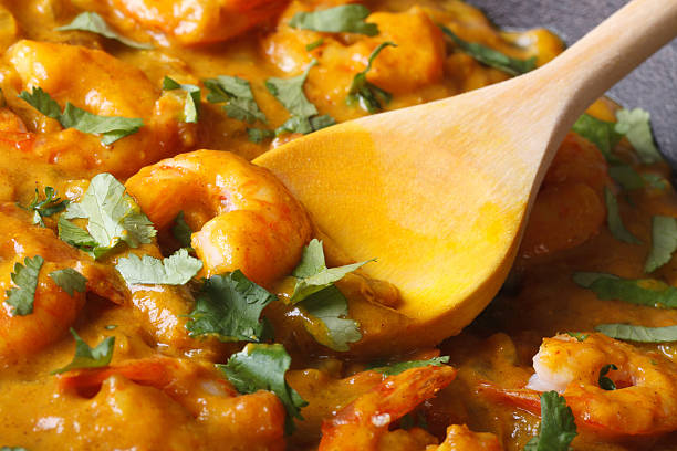 istock Shrimps in curry sauce with a wooden spoon 479656862
