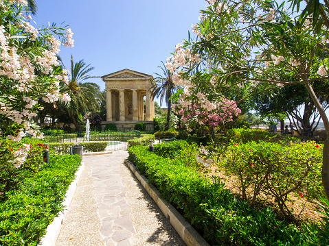 A beautiful Lower Barrakka Garden in Valletta which is The Fortress City and Malta's capital located on Island in Mediterranean Sea.  It has impressive bastions, forts and cathedrals and is considered as European Art City and a World Heritage City. View from entrance, in background is beautiful view of Three cities.