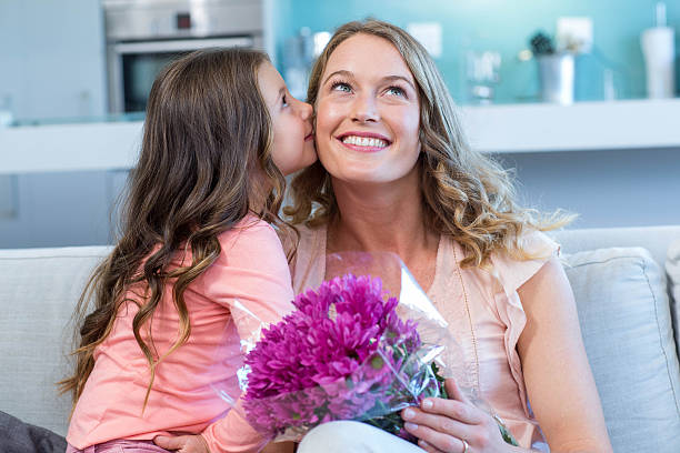 istock Daughter surprising mother with flowers 479658746