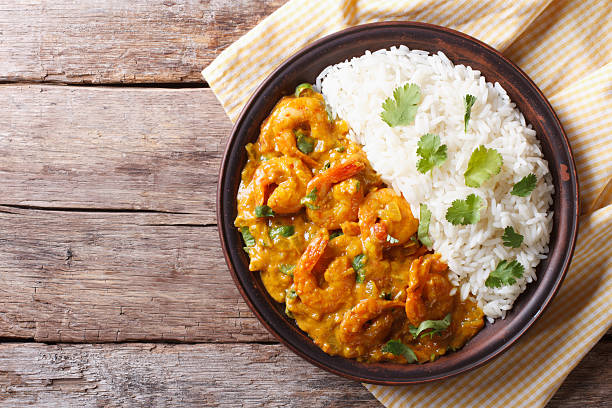 Shrimps curry with rice on plate. horizontal view from above Shrimps in curry sauce and rice on a plate. horizontal view from above fish in a bowl stock pictures, royalty-free photos & images