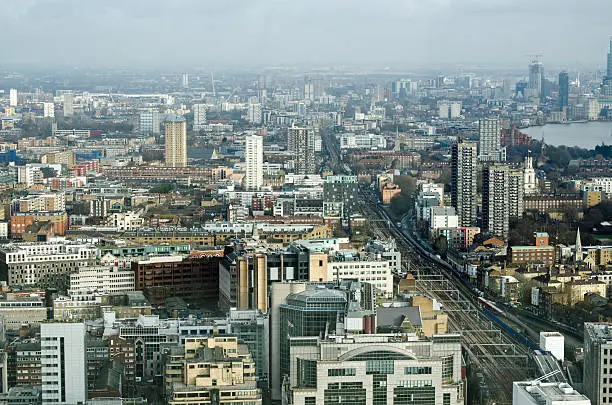 View from a tall building in the City of London looking east towards the East End with Wapping, Poplar, Shadwell, Limehouse, Whitechapel all visable as the modern  office blocks of the financial district give way to the social housing of East London. The main railway line to London's Fenchurch Street Station is on the right hand side.