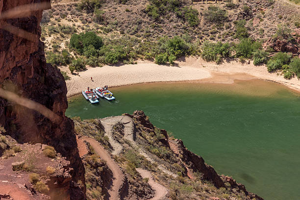 A view from above of rafts on the Colorado River at the bottom of the Grand Canyon. They are beached and taking a break.