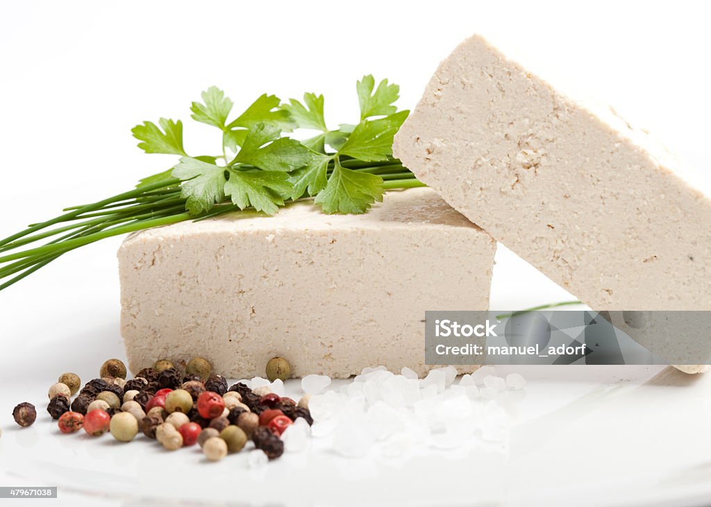raw tofu with salt, pepper and fresh spices tofu cubes with spices on white background 2015 Stock Photo