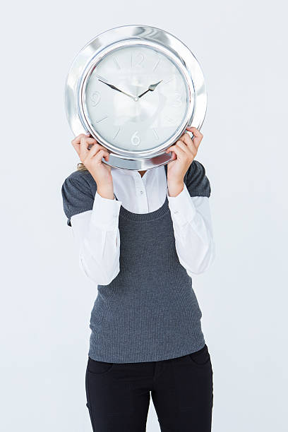 istock Woman holding clock in front of her head 479672496