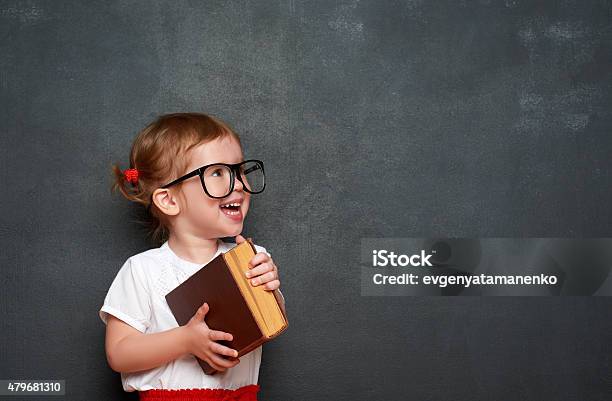 Glückliche Mädchen Im Schulmädchen Mit Buch Von Blackboard Stockfoto und mehr Bilder von Schreibtafel