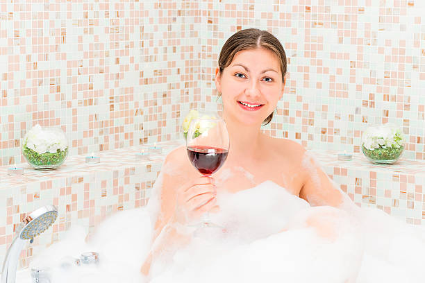 chica romántica con una copa de vino en el jacuzzi - bathtub women naked human face fotografías e imágenes de stock