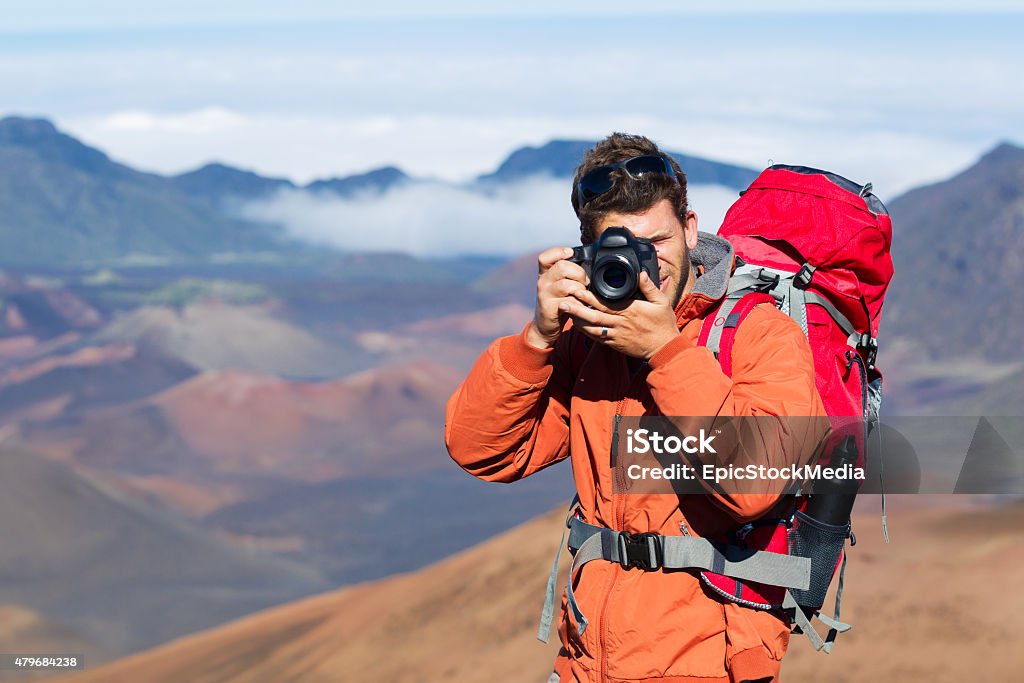 Nature Photographer taking Pictures Outdoors Photographer taking pictures outdoors on hiking trip. Outdoor nature photography. Adult Stock Photo