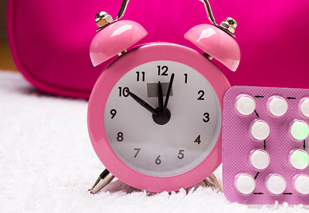 alarm clock and contraceptive pills stock photo