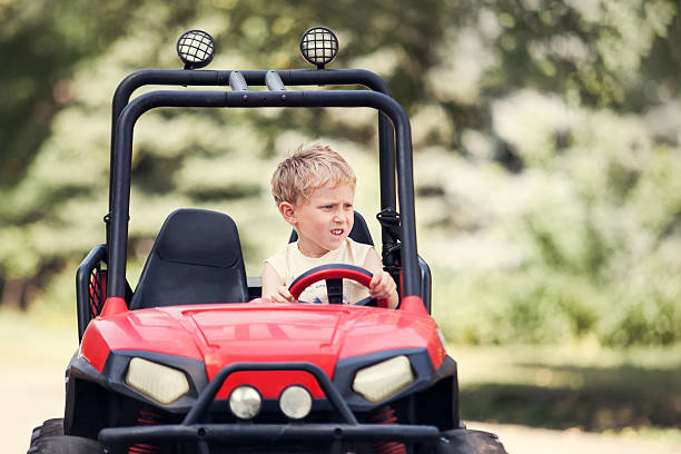 istock Little boy drive a mini electric car in park 479688886