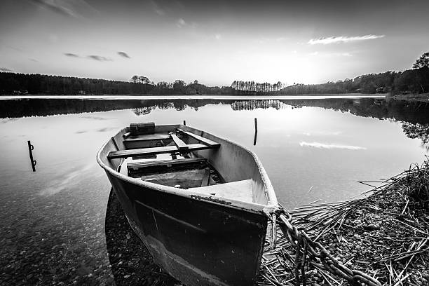 A tranquil rural Wisconsin lake stretches out from the dock, with a lone kayaker paddling in the distance. In the right-hand corner, a fishing line and bobber gently rest on the calm water, adding a touch of quiet human presence to the serene natural scene.
