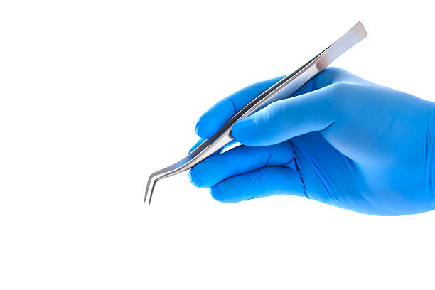 Doctor's hand holding tweezers with clipping path Doctor's hand holding tweezers with clipping path dental equipment hand stock pictures, royalty-free photos & images