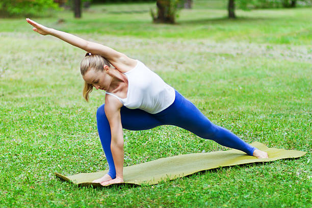 istock woman doing yoga on the grass 479705520