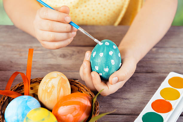 Child hands paint egg stock photo