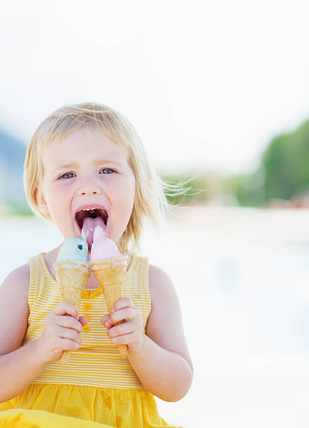 istock happy baby eating two ice cream horns 479715079