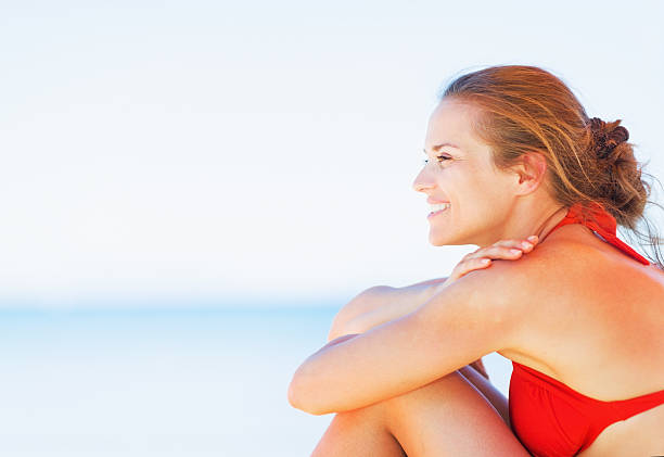 istock Happy young woman sitting on beach 479715711