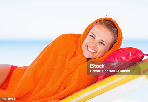 Sonriente Joven Mujer Envuelto En Toalla Sentar En La Cama Solar Foto de stock y más banco de imágenes de Acostado