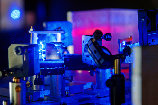 Blue laser on optical table in a quantum optics lab.