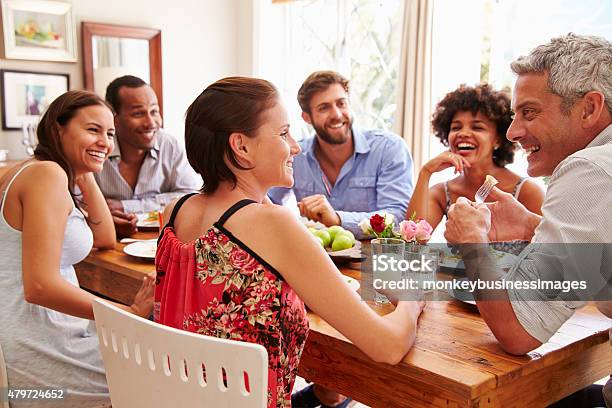 Friends Sitting At A Table Talking During A Dinner Party Stock Photo - Download Image Now