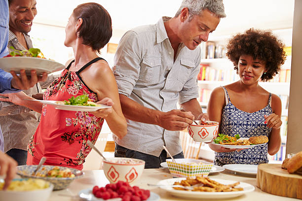 istock Friends serving themselves food and talking at dinner party 479724944