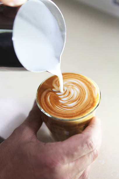 istock barista pouring milk in coffee, close-up 479725697