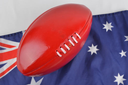 An AFL football and Australian flag