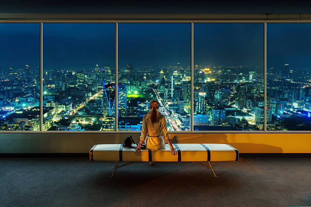 istock Woman looks at night cityscape 479727053