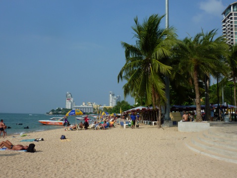 Pattaya, Thailand - December 15, 2013: Locals and tourist sunbathing and relaxing at Pattaya beach, a popular tourist resort.