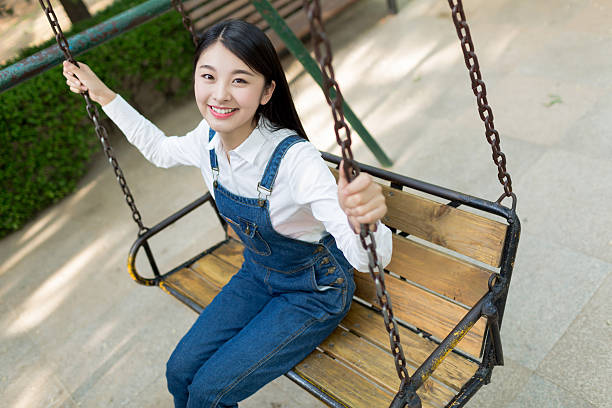 beautiful asian girl sitting on the swing happy to play
