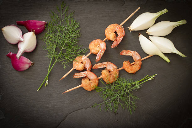 istock Grilled shrimp with dill on a black stone 479729880