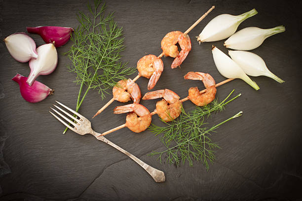 istock Grilled shrimp with dill on a black stone 479729882