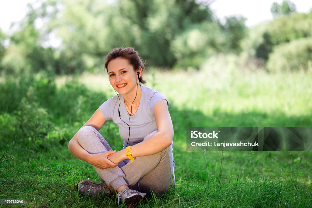 woman exercising outdoors with headphones woman exercising outdoors with headphones. Female athlete listening music during fitness training outdoor. 2015 Stock Photo