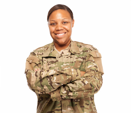 Black female army soldier smiling with arms crossed.