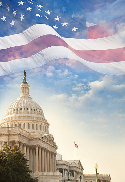 United States Capitol building with American flag superimposed on sky stock photo
