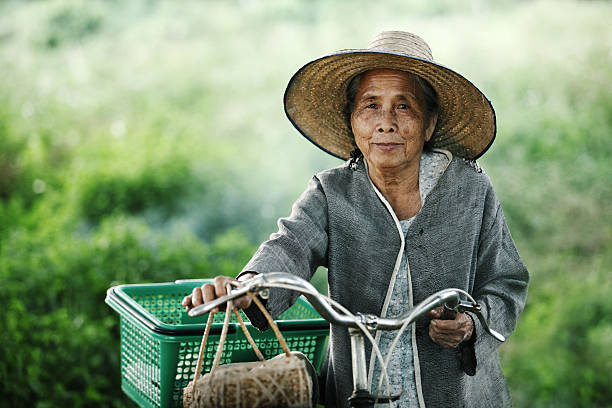 vecchia donna coppia con le loro moto all'aperto - povertà asia foto e immagini stock