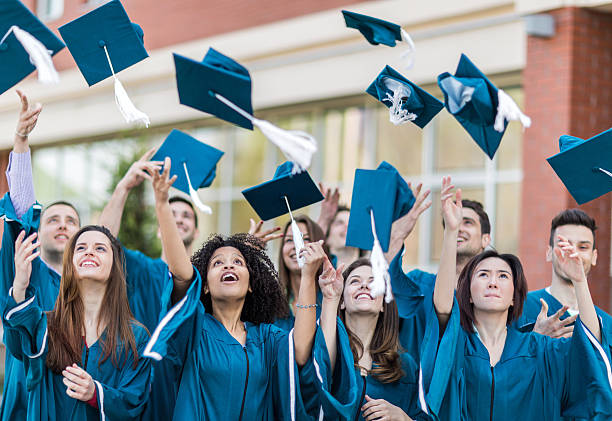 istock Happy graduation students throwing mortar board hats in the air. 479765206