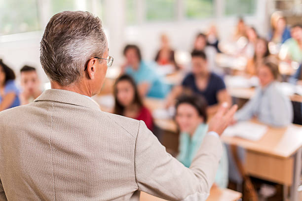 istock Rear view of teacher giving a lecture in the classroom. 479765246