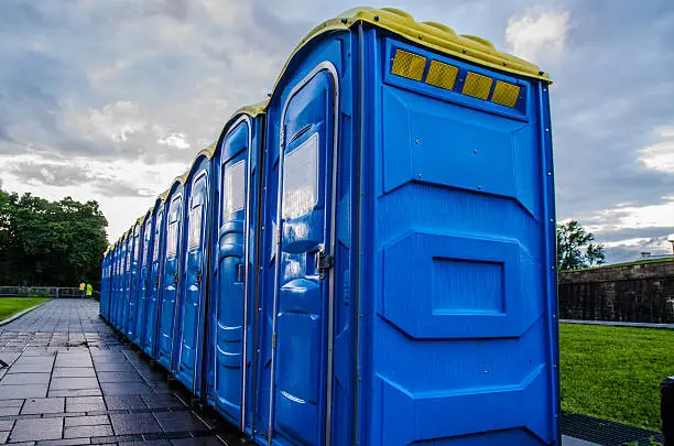 Row of blue chemical and portable toilets for an outdoor party