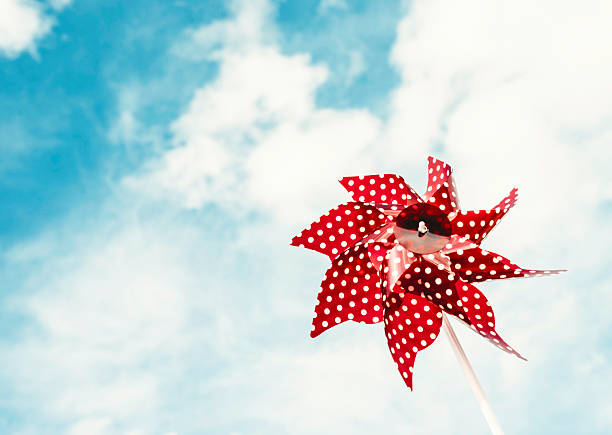 Closed window shutters with red flowers and pinwheel in Venice, Italy
