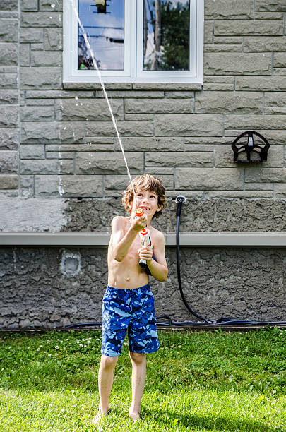 istock Boy shooting water from water gun 479783238