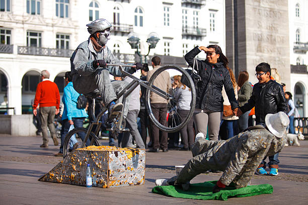 Hamburg, Germany - October 4, 2014: Mother and her son observing an interesting street artists on the bicycle in front of the City Hall in Hamburg.
