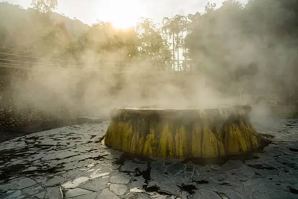 steam over ranong hot spring in sun light in the morning