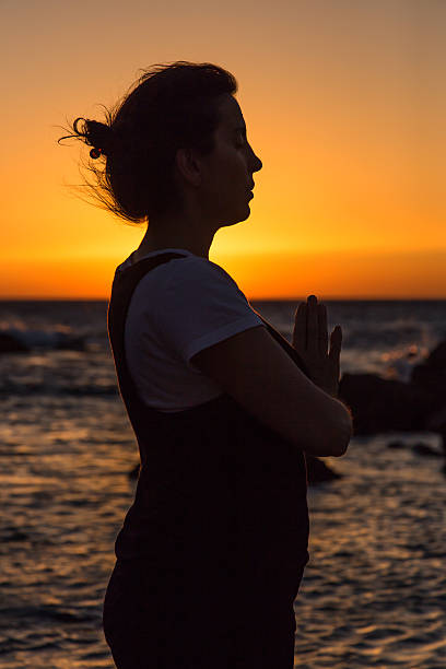 istock Silhouette young woman practicing yoga on the beach at sunset. 479797974