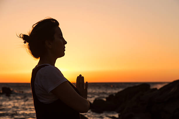 istock Silhouette young woman practicing yoga on the beach at sunset. 479798632