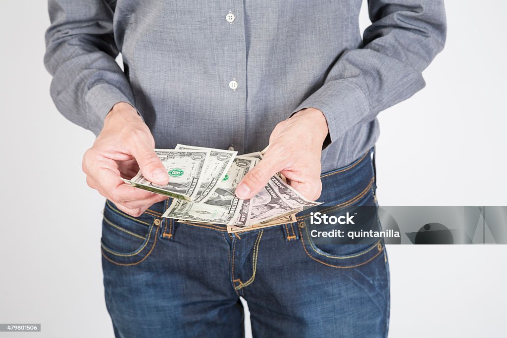 woman hands counting dollars woman blue jeans trousers and grey shirt counting currency money cash one five ten and twenty dollar banknotes in her hands isolated over white background 2015 Stock Photo